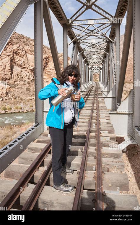 Woman Serving Mate A Traditional Argentine Hot Drink In The Middle Of A Railway Bridge