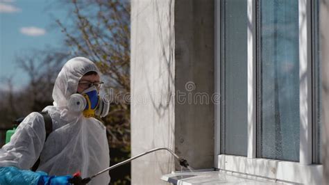 El Trabajador Con Traje Protector Rocia Un Desinfectante En La Ventana