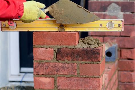 Bricklaying Laying A Brick And Checking It Is Level Stock Photo