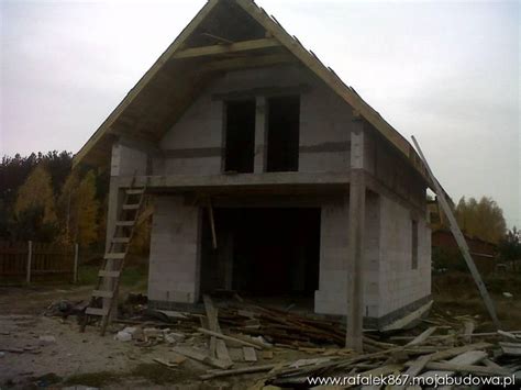 A House Under Construction With A Ladder Going Up To It S Roof And Windows