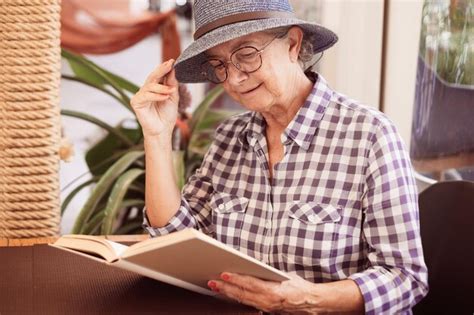 Retrato De Una Hermosa Anciana Con Sombrero Sentada En La Mesa De Un