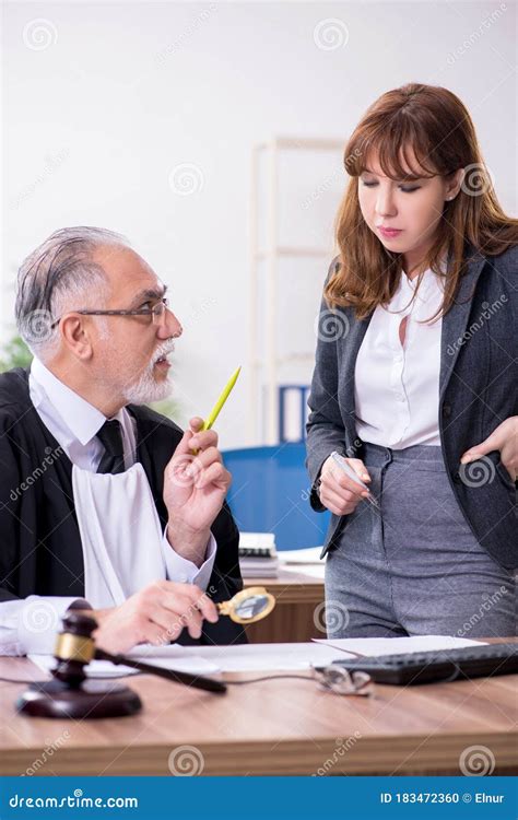 Old Male Judge And His Young Secretary In The Office Stock Photo