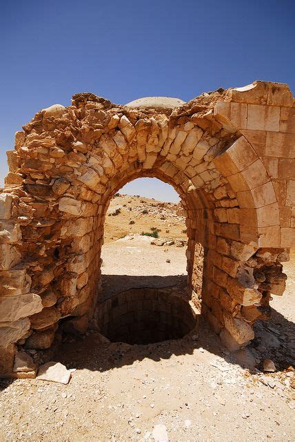 An Old Stone Arch In The Desert With No People Around It And Blue Sky Above