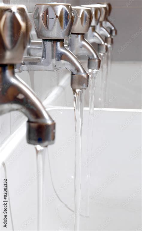 Steel Taps With Drinking Water Flowing In College Bathroom Stock Foto