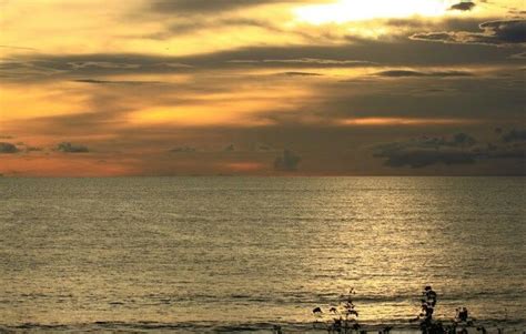 The Sun Is Setting Over The Ocean With Clouds