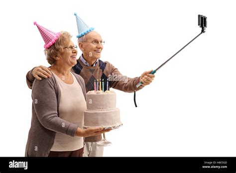 Felices los ancianos con gorros de fiesta y una tarta de cumpleaños