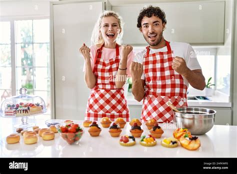 Couple Of Wife And Husband Cooking Pastries At The Kitchen Celebrating Surprised And Amazed For