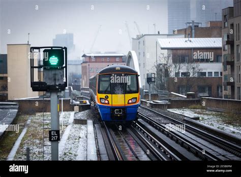 A Overground Train Approaches Haggerston Station On A Cold Snowy Day