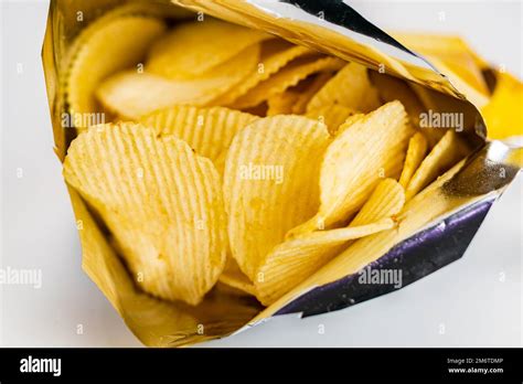 View Of Dry Crispy Fried Corrugated Potato Chips In Open Bag Stock