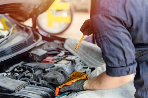 Premium Photo Mechanic Staff Looking Dipstick Car Engine Oil Check