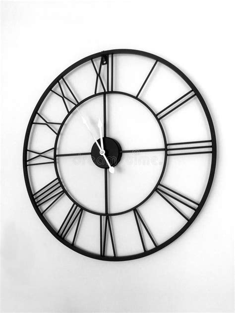 A Roman Numeral Clock Hanging on the Wall Black and White Stock Photo ...