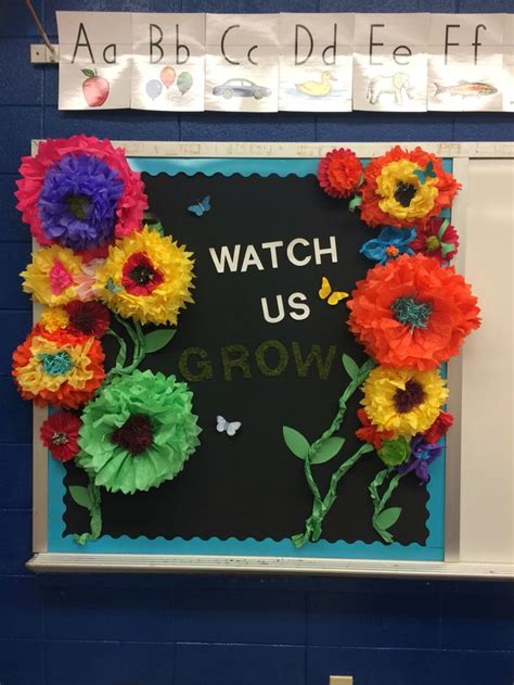 A Classroom Bulletin Board With Flowers On It That Says Watch Us Grow