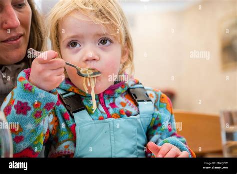 Cute Blonde Girl Eating Beef Noodle Soup In A Restaurant With Her