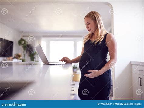 Pregnant Woman Standing By Kitchen Counter Working From Home On Laptop Stock Image Image Of