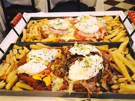 Two Trays Filled With Different Types Of Food On Top Of A Table Next To