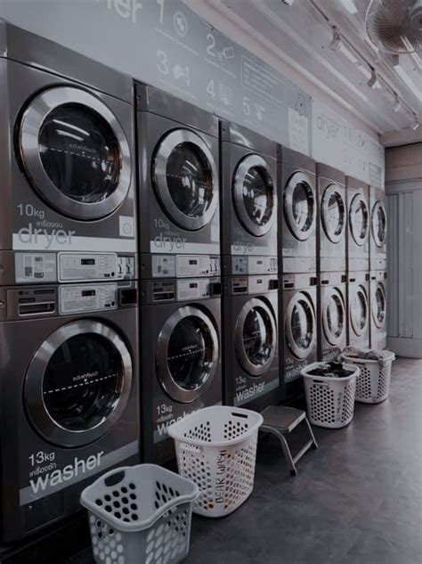 a row of washers and dryers in a laundry room