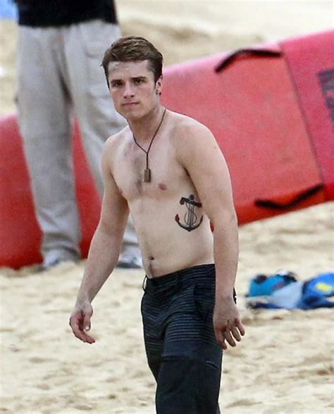 Shirtless Young Man Walking On The Beach With An Anchor Tattoo On His