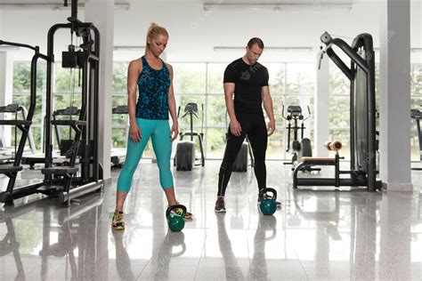 Premium Photo Fitness Couple Using Kettlebells Inside Gym