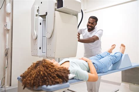 Smiling Male Doctor Doing Xray Of Female Patient In Medical Examination