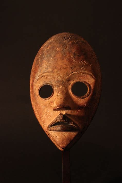 An Old Mask With Two Eyes And A Moustache On It S Face