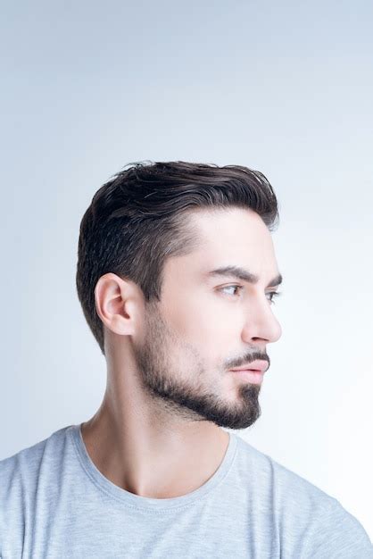 Retrato De Un Joven Apuesto En Camiseta Gris Posando Contra La Pared