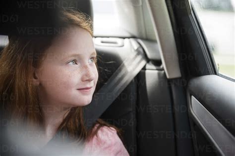 Smiling Caucasian Girl In Car Looking Out Window Stock Photo