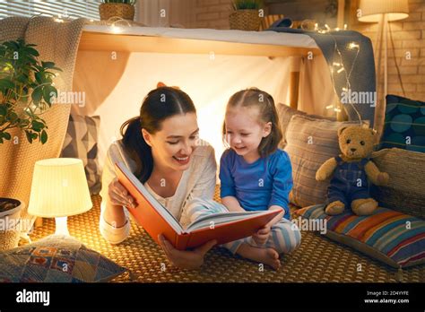 La familia a la hora de acost Mamá y su hija están leyendo un libro en