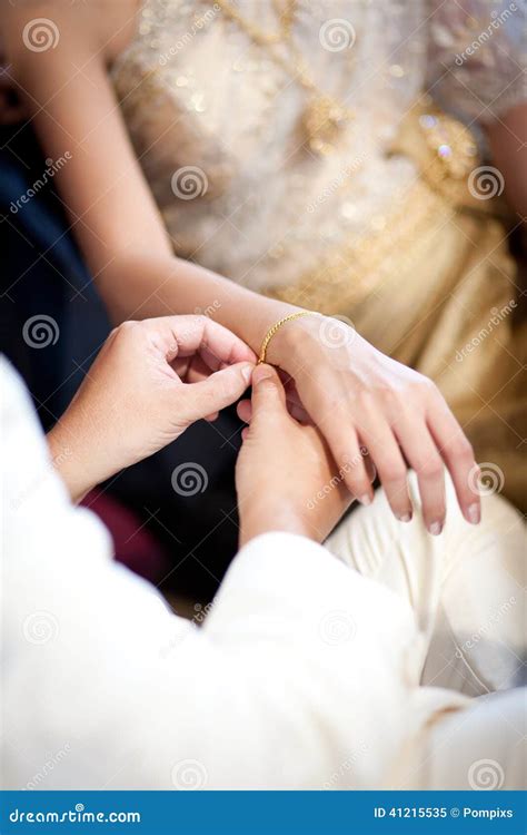 Groom Wearing Gold Bracelet For His Bride In Wedding Ceremony Stock