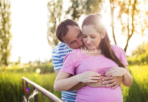 Happy Young Pregnant Couple Hugging In Nature Royalty Free Stock Image