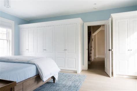 A Bedroom With Blue Walls And White Closets In The Corner Along With A