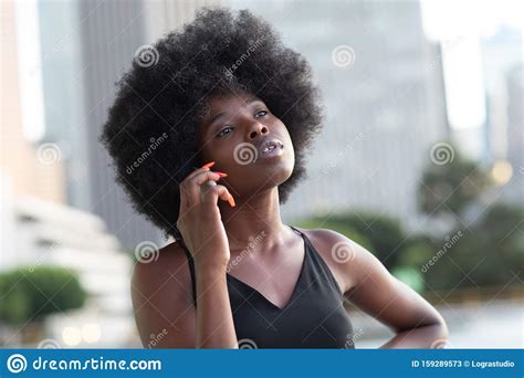 A Pensive African American Woman Talking On A Cell Phone City