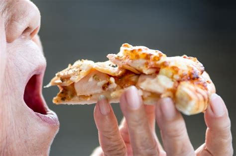 Premium Photo | Cropped image of person eating pizza