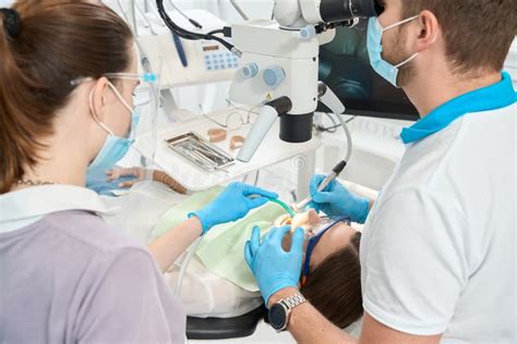 Dentist Performing Interdental Tartar Removal Under Microscope Stock ...