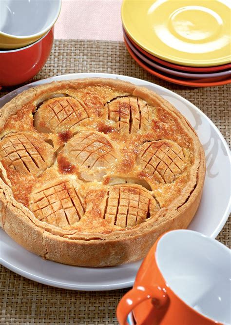 A Pie Sitting On Top Of A White Plate Next To Cups And Saucers