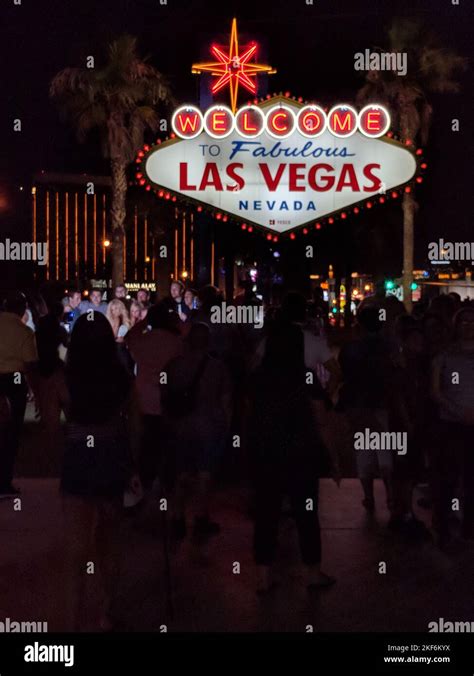 A Vertical Shot Of The Las Vegas Boulevard Full Of Crowd At Night With