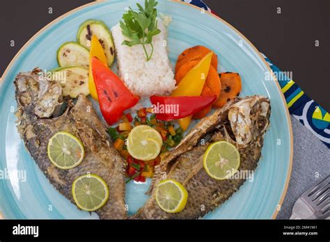 Grilled fish a la carte meal with white steamed rice on plate at restaurant table setting Stock ...