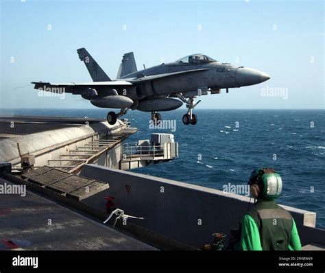 US Navy An Air Department Member Watches As An F A 18C Hornet Assigned