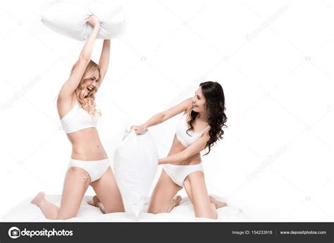 Young women playing pillow fight Stock Photo by ©DmitryPoch 154233918