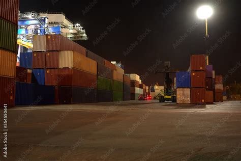 operation of container terminal at night. Unloading container ship at night. Mooring cranes ...