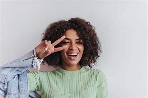 Photo Dune Fille Brune Fait Un Clin Dœil Et Montre Un Signe De Paix Femme Heureuse En Tee