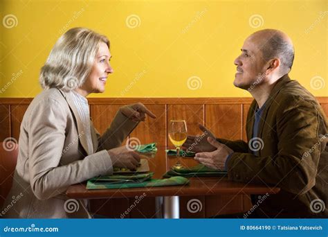 Man And Woman Sitting Across From Each Other At A Restaurant Stock