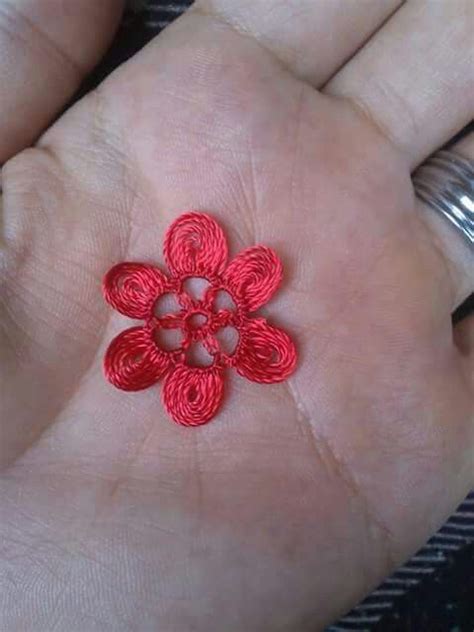 A Person S Hand Is Holding A Red Crochet Flower