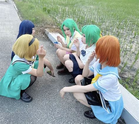 Four Anime Girls Sitting On The Ground With Their Hands Together