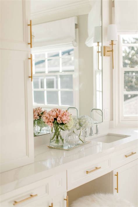 White Marble Bathroom with Gold Sconces and Chrome Faucets