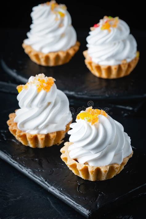 Cesta De Mini Pasteles Con Crema Merengue Sobre Fondo Negro Foto De