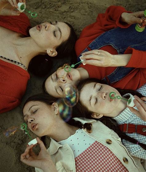 Three Women Laying On The Ground With Bubbles In Their Mouths And