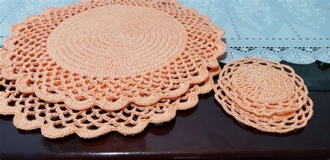 There Is A Doily And Two Place Mats On The Table