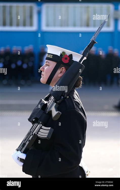 A Poppy Is Seen In The Cap Of A Royal Navy Rating As Members Of The