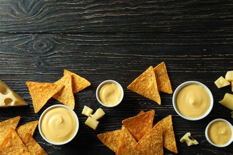 Premium Photo | Cheese sauce, cheese and chips on rustic wooden table