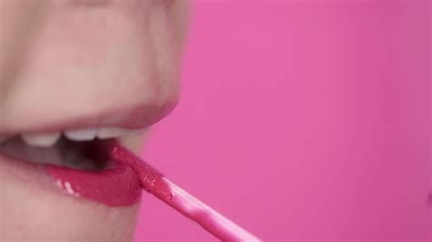 Close Up Of A Woman Applying Pink Lipstick On Pink Background 28195850